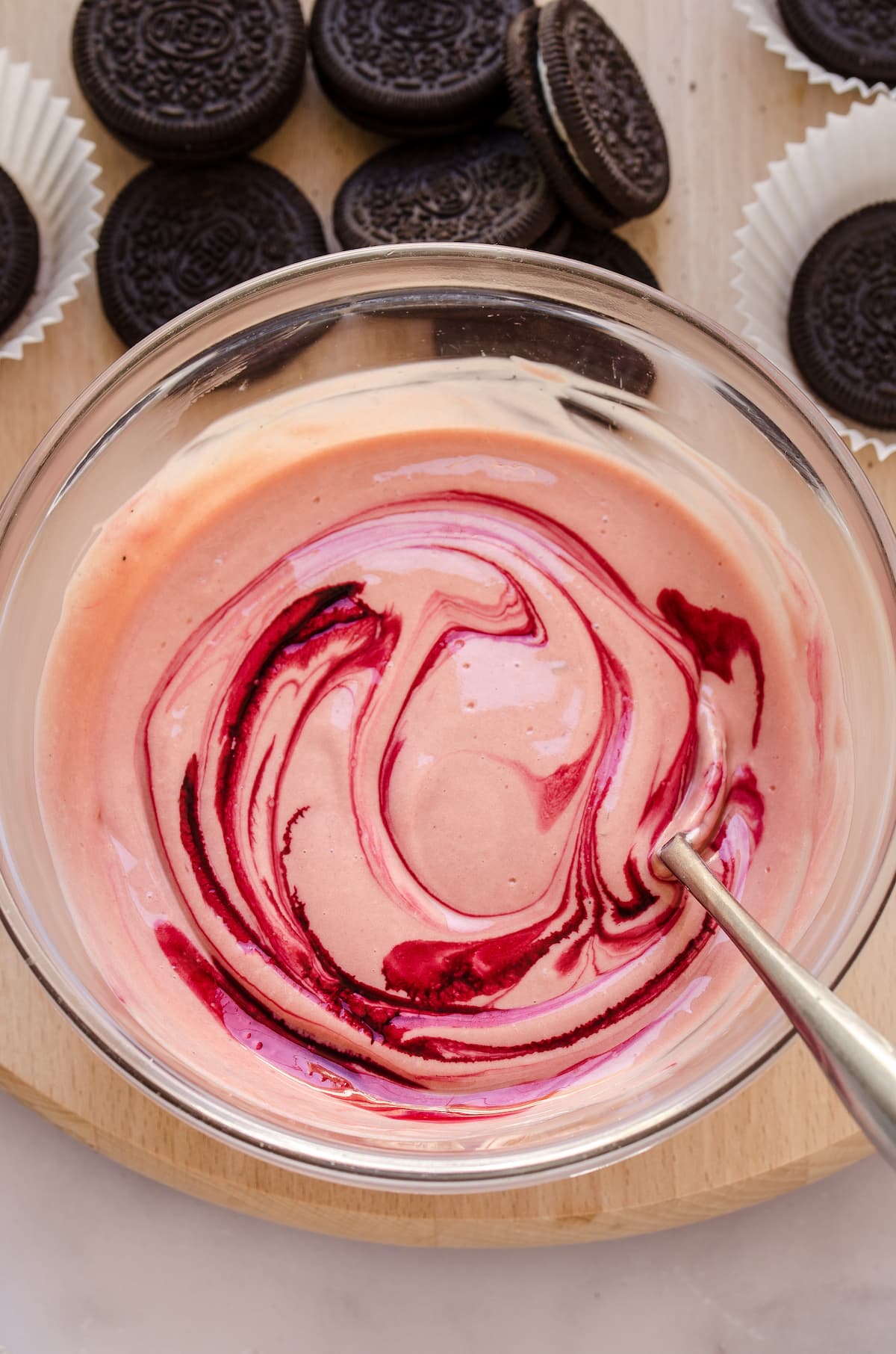 Overhead view of red velvet cheesecake batter in a mixing bowl