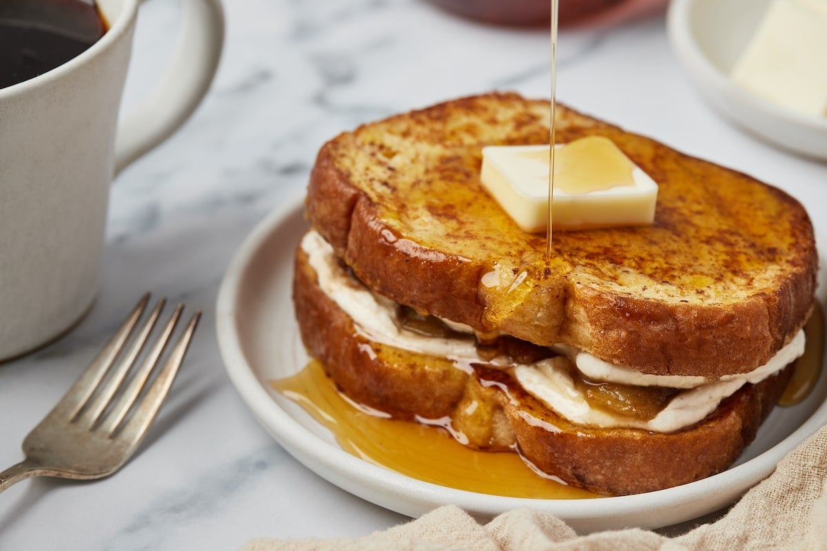 A small plate of stuffed French toast with cream cheese and bananas.