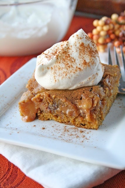 pumpkin caramel blondies with whipped cream on top all on a plate