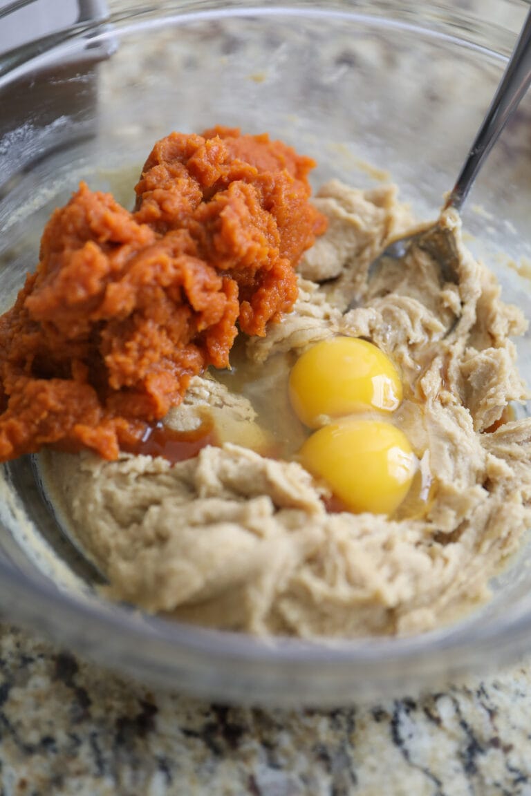 adding eggs and pumpkin to batter