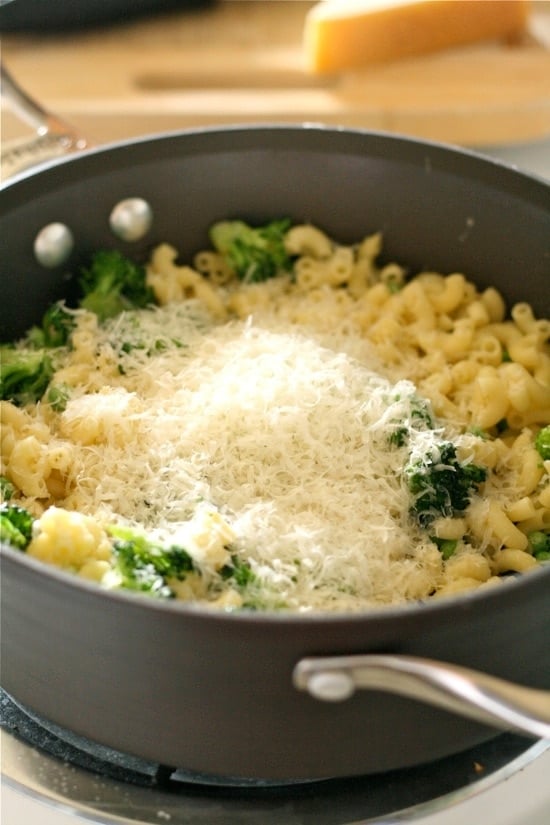 Adding cheese to pot full of other ingredients for broccoli mac and cheese