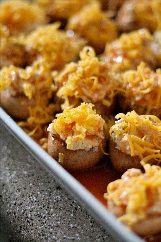 grated cheddar cheese on top of stuffed mushrooms