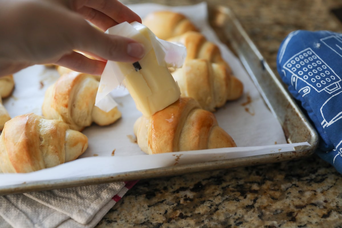 rubbing butter on baked crescent rolls