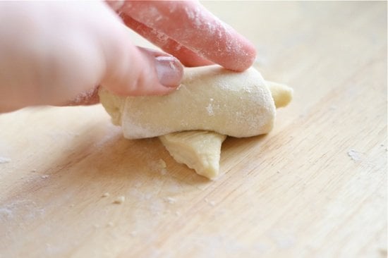 rolling dough into crescent shape