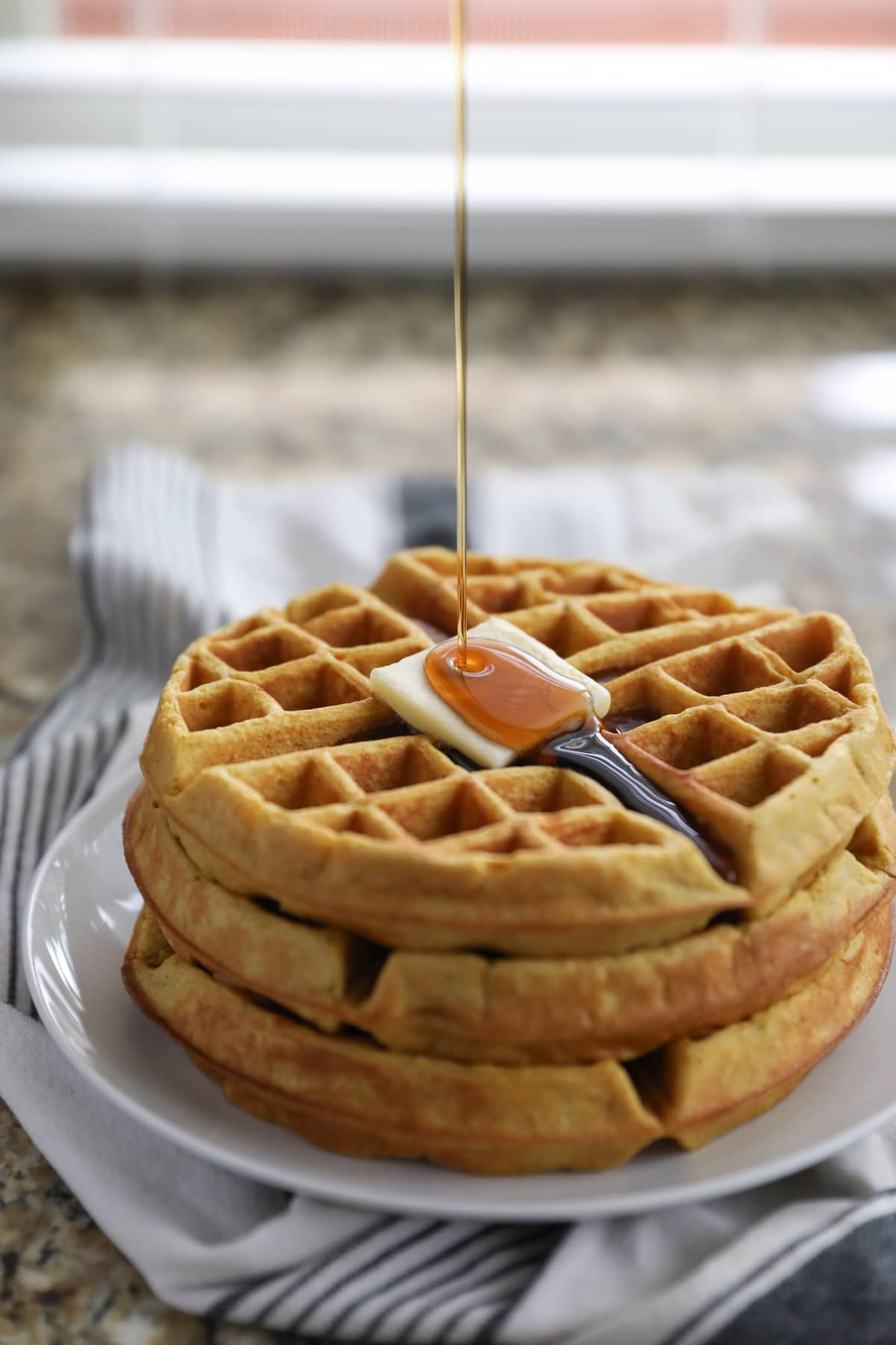 pouring syrup on pumpkin waffles