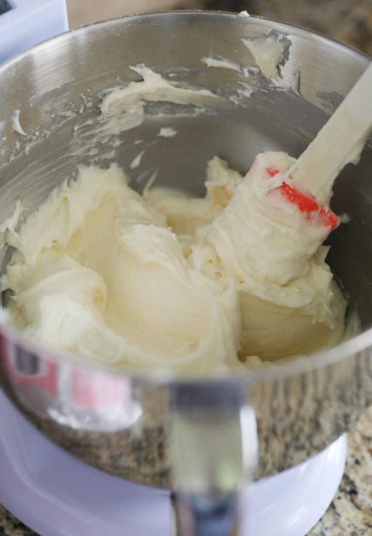 stirring cream cheese frosting with spatula