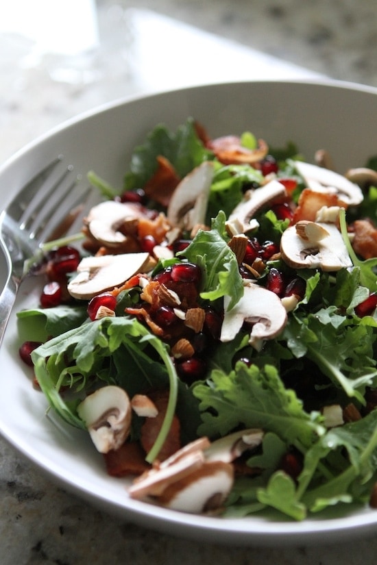 pomegranate salad in a white bowl with fork