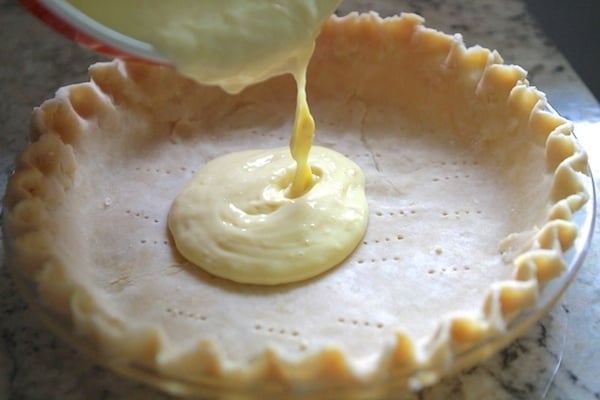 Pouring lemon cream filling into the pie crust