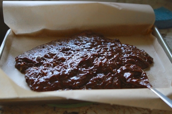 zucchini brownie batter in parchment lined baking sheet
