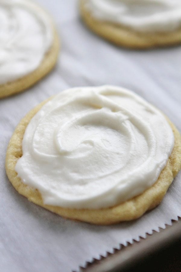 frosted sugar cookies on parchment paper