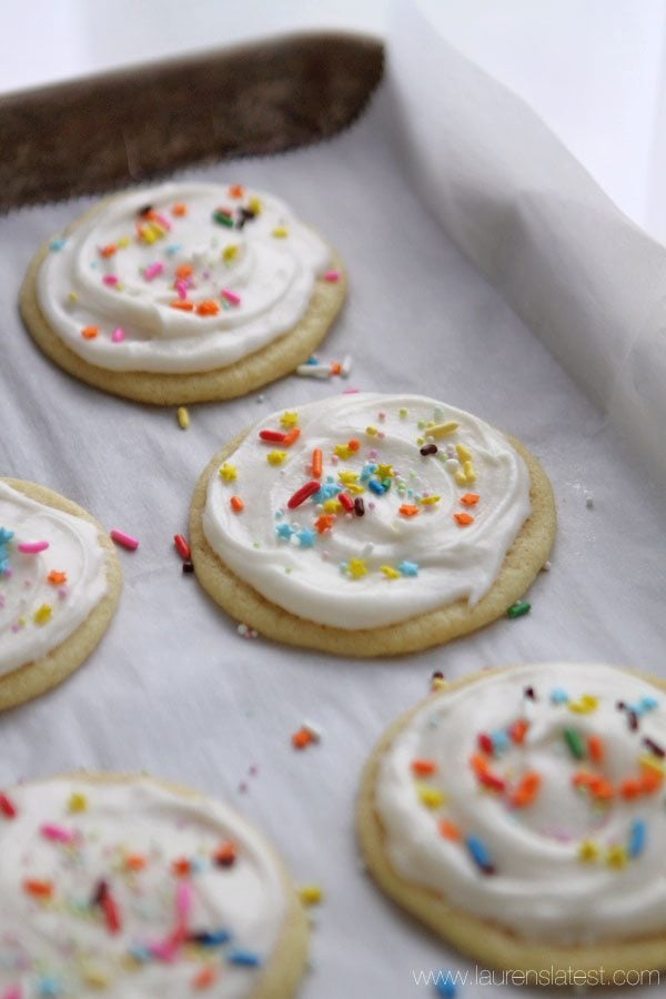 frosted sugar cookies on a baking sheet