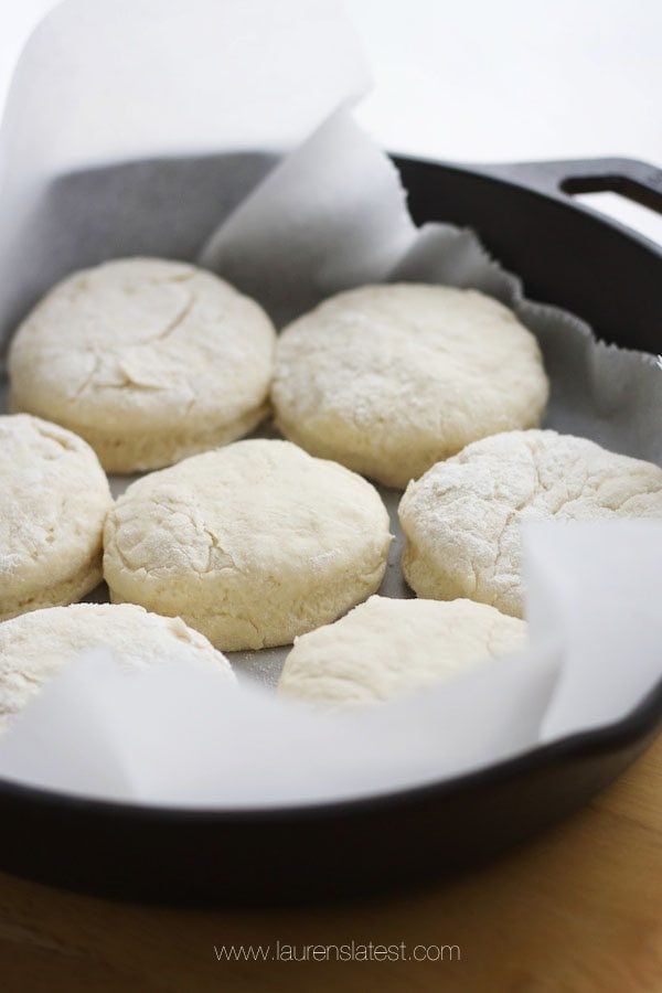unbaked biscuits in a parchment paper lines cast iron pan