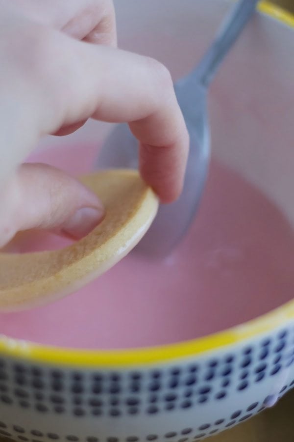 cookie being dipped in icing