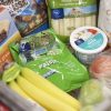 A shopping cart filled with fruits and vegetables, perfect for snack ideas for kids.