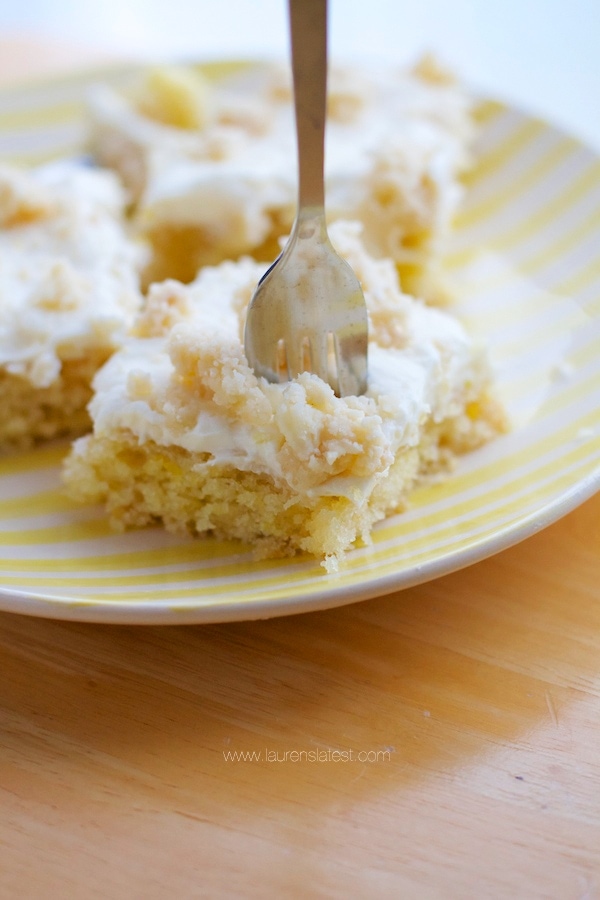 A slice of Lemon Crumb Cake on a yellow plate with a fork.