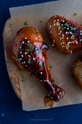 Sweet and Spicy Asian chicken wings on a wooden cutting board.