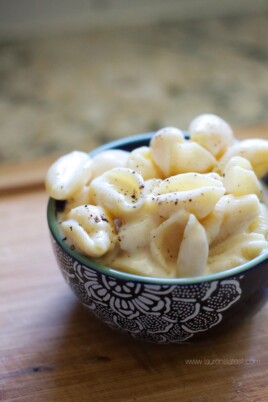 Shells and White Cheddar macaroni and cheese in a bowl on a cutting board.