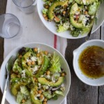 Two bowls of spring salad with avocado and chickpeas.