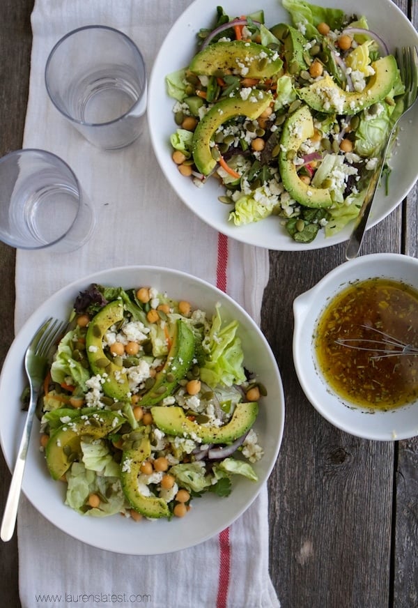 Two bowls of spring salad with avocado and chickpeas.