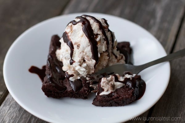 A plate with scrumptious chocolate brownies and creamy ice cream.