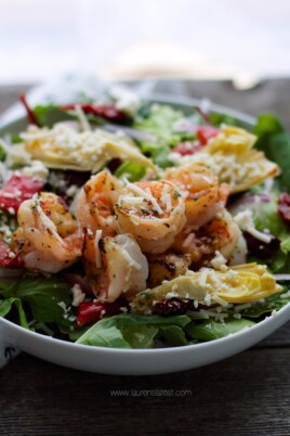 A salad with shrimp and feta cheese.