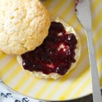 English scones with jam on a yellow plate.