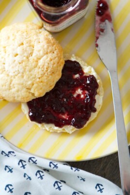English scones with jam on a yellow plate.