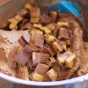 A bowl full of chocolate pieces, topped with Reese's Peanut Butter Cup Frosting.