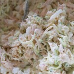 A bowl of a healthy chicken salad with a spoon in it.