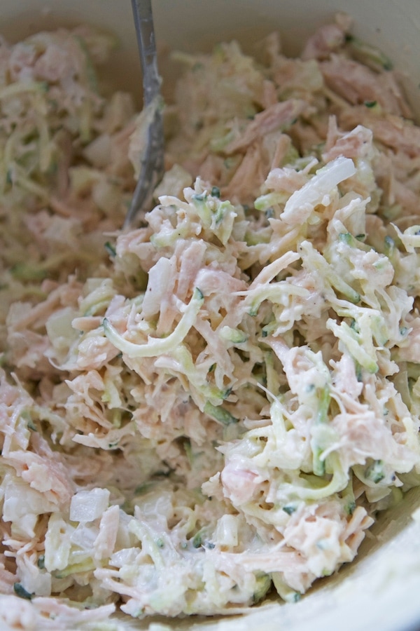 A bowl of a healthy chicken salad with a spoon in it.