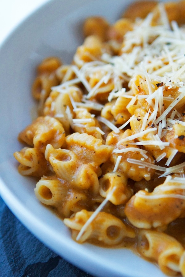 A bowl of pasta topped with cheese and Parmesan.