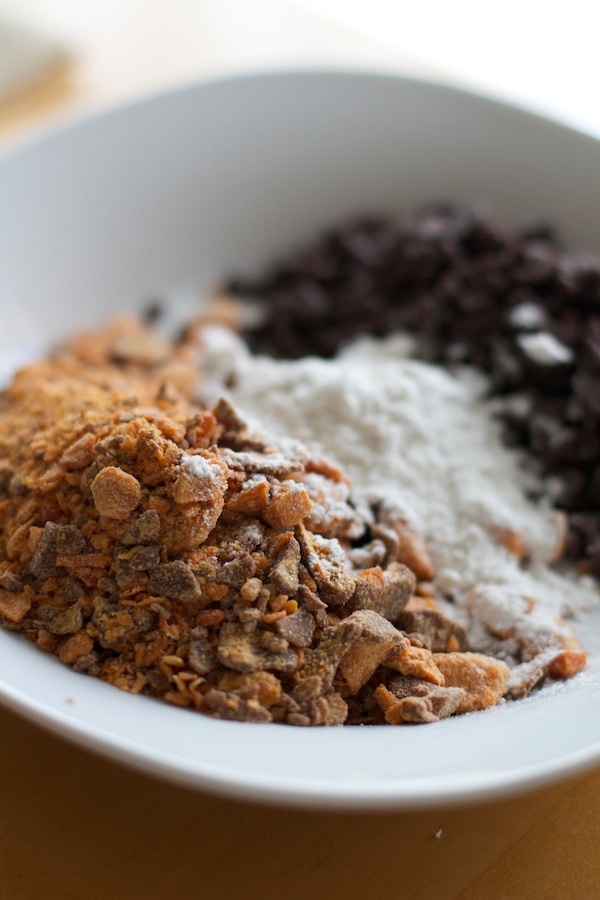 crushed butterfingers, chocolate chips and flour in a white bowl