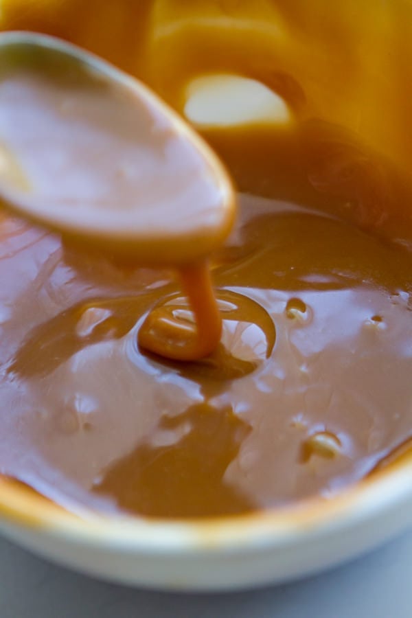 spooning caramel sauce in a bowl