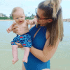 mom holding baby in ocean
