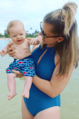 mom holding baby in ocean
