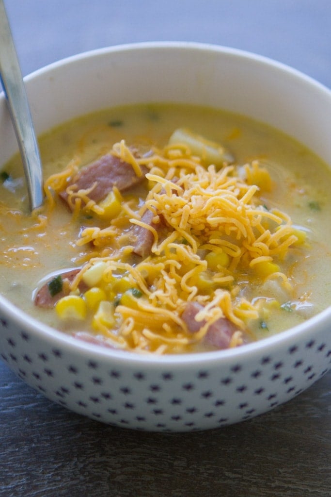 sausage corn chowder in a bowl with cheese on top