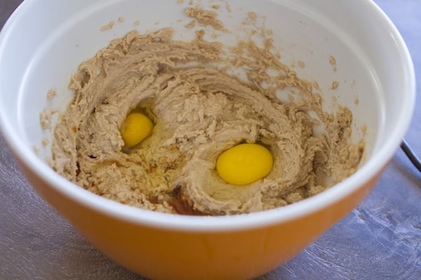 Adding eggs to dough mixture