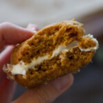 hand holding pumpkin whoopie pie with bite missing
