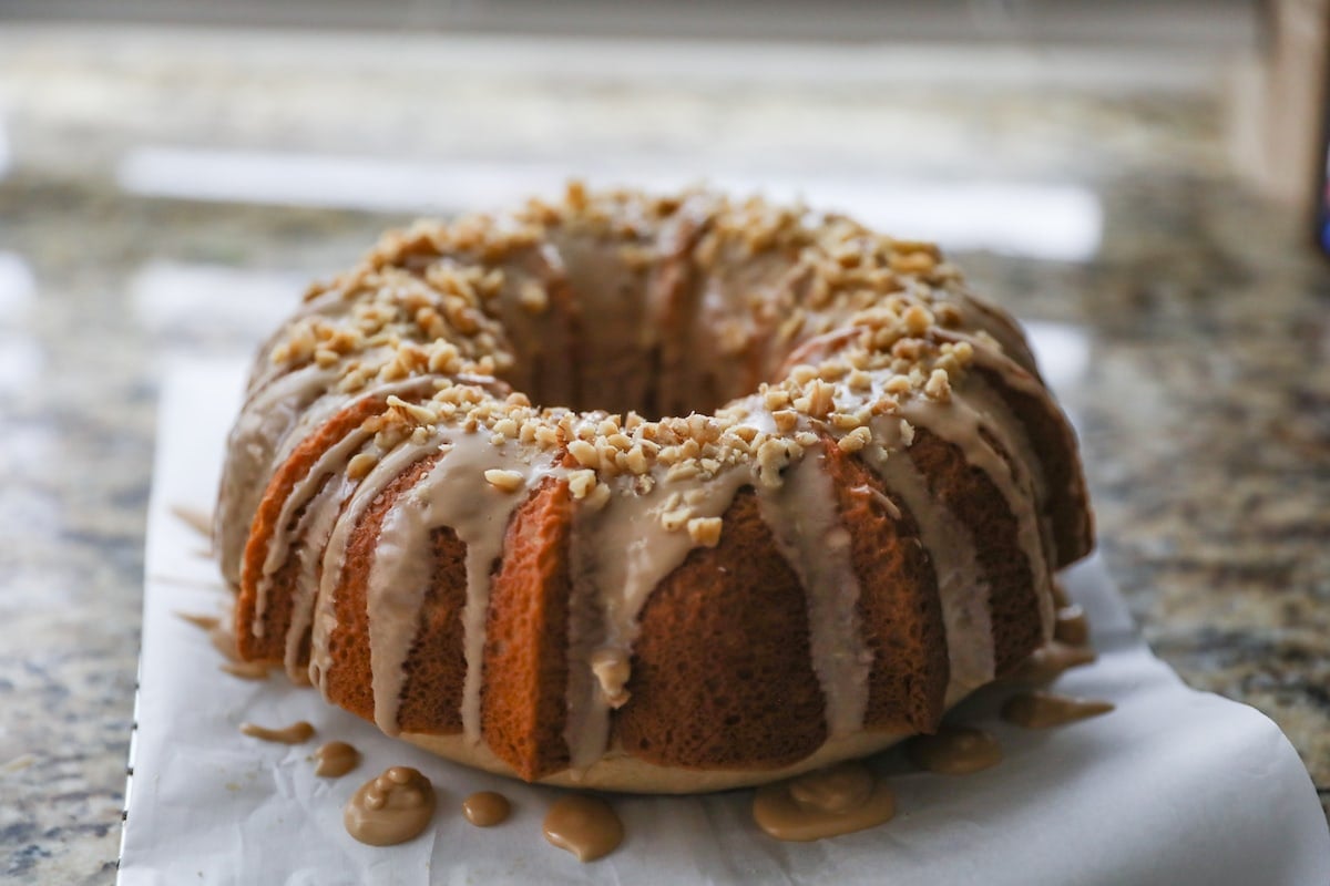 maple cake on parchment paper with icing and nuts