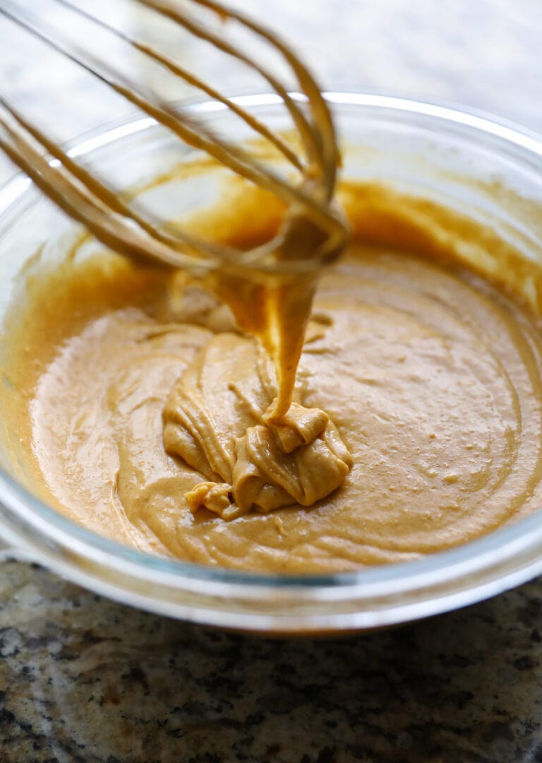 pumpkin cake batter in glass bowl with whisk
