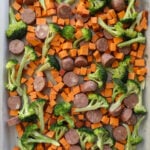 sausages and vegetables on baking sheet before roasting