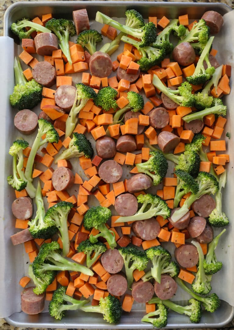 sausages and vegetables on baking sheet before roasting