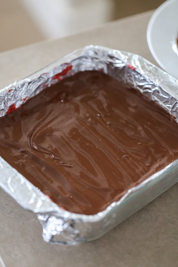 Adding melted chocolate over red velvet mixture