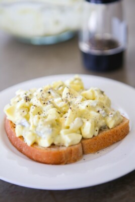 healthy egg salad on a piece of bread all on a white plate