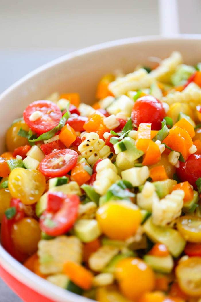 Summer Corn Avocado Basil Salad is a healthy salad perfect for the hot summer months that is filled with fresh corn, ripe avocados, sweet basil, cherry tomatoes, peppers and zucchini.