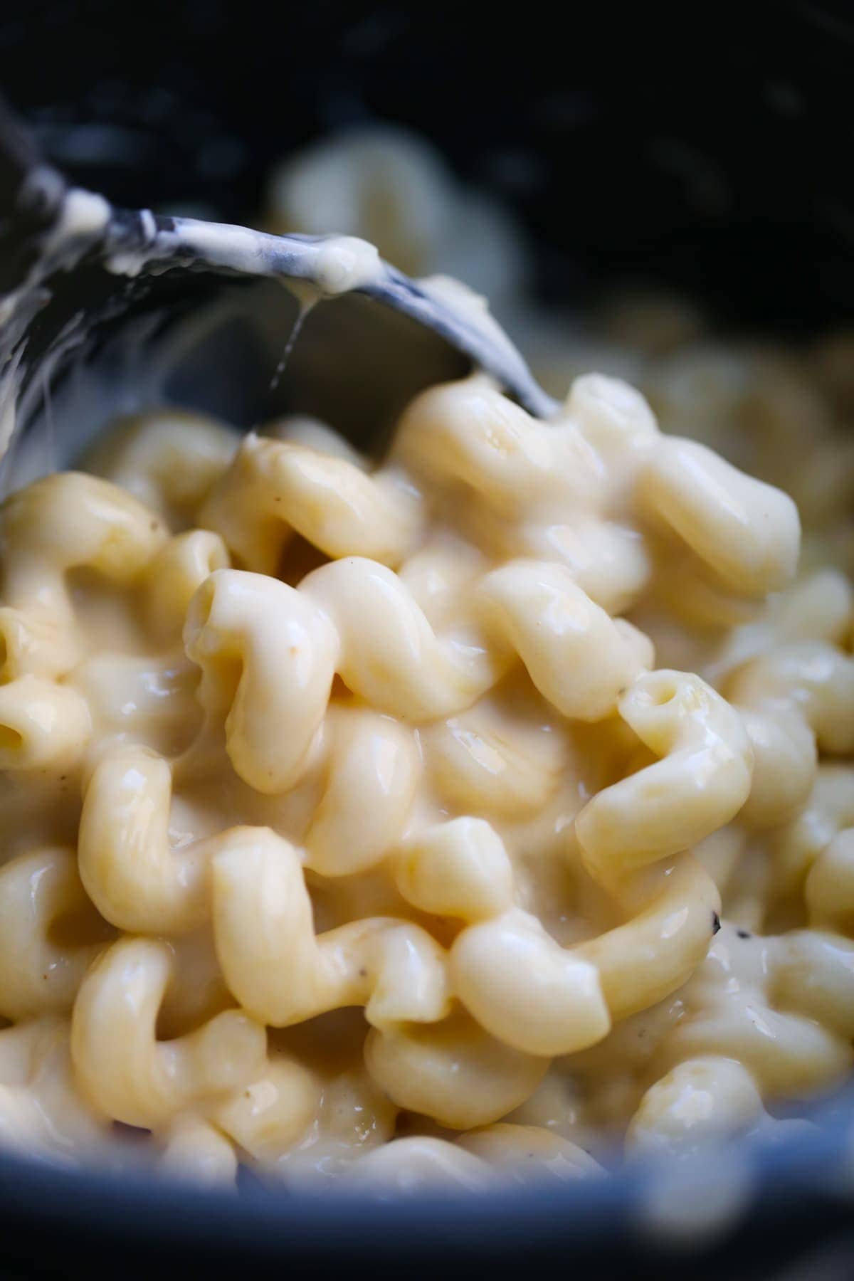 scooping macaroni and cheese from the instant pot