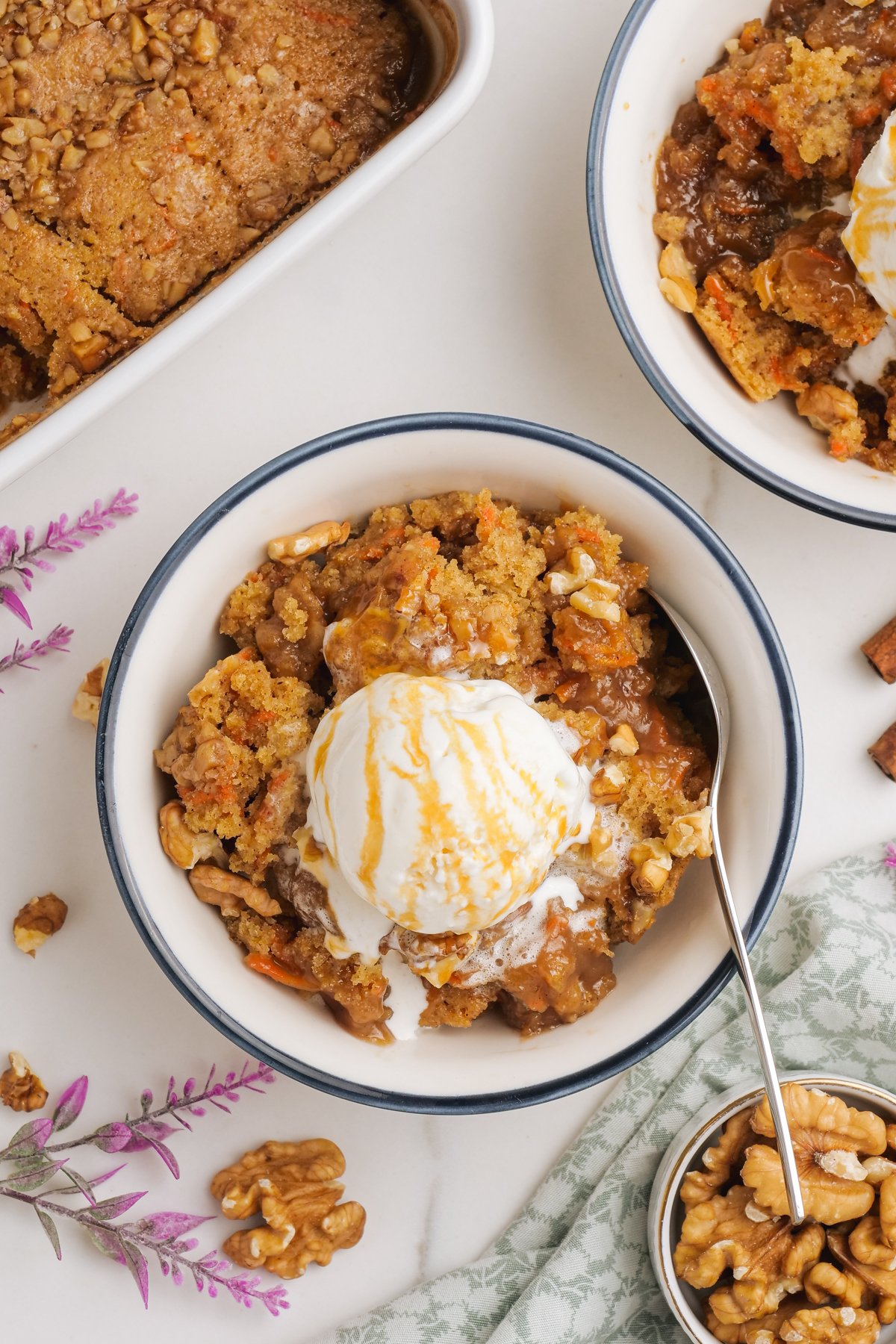 carrot cake cobbler in a dish with a scoop of ice cream on top