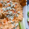 close up of buffalo chicken dip with celery in it
