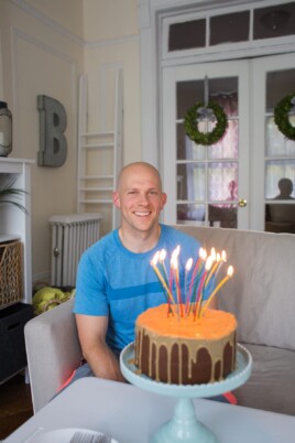 Gordon smiling behind his lit birthday cake