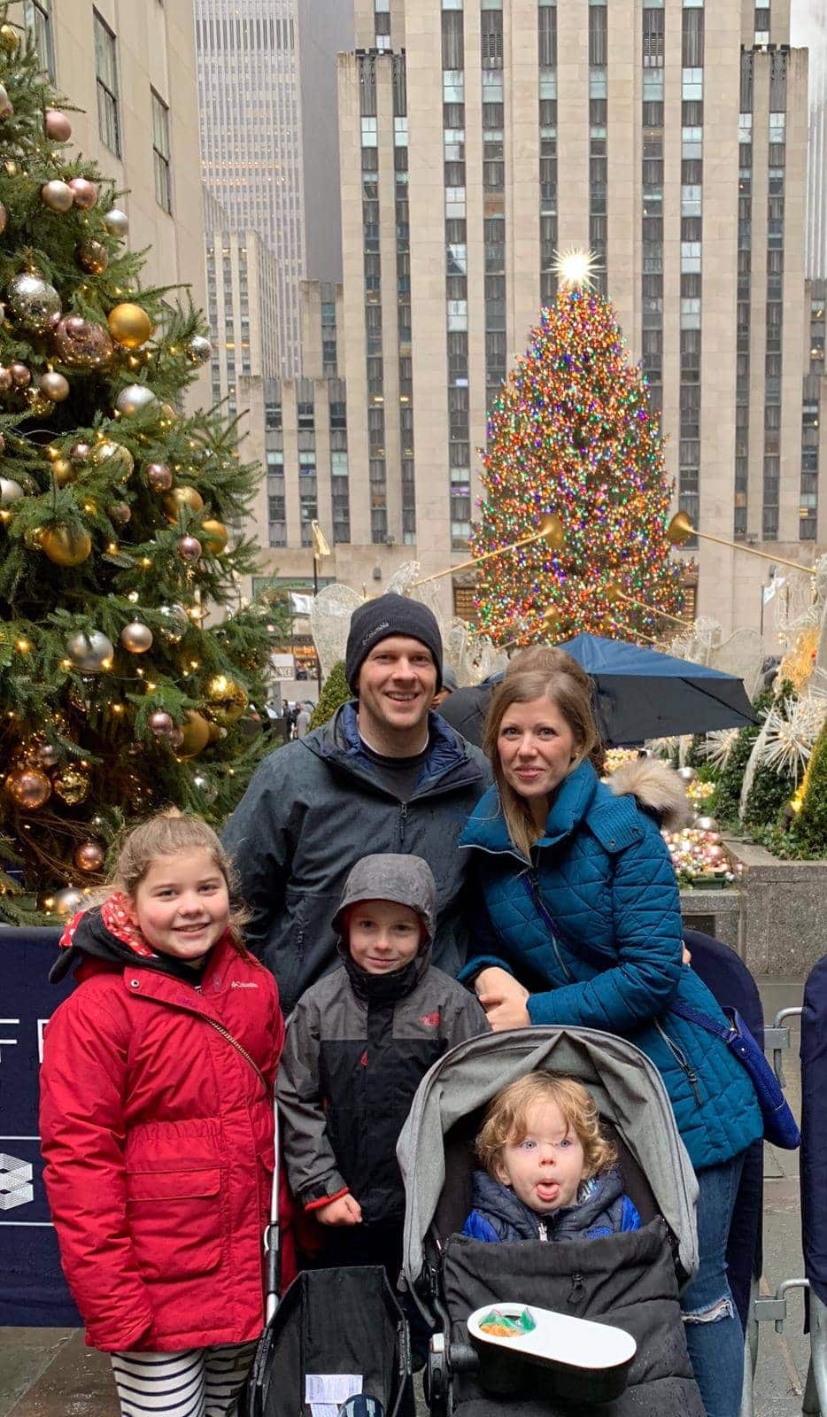 Brennan family in front of Christmas trees outside